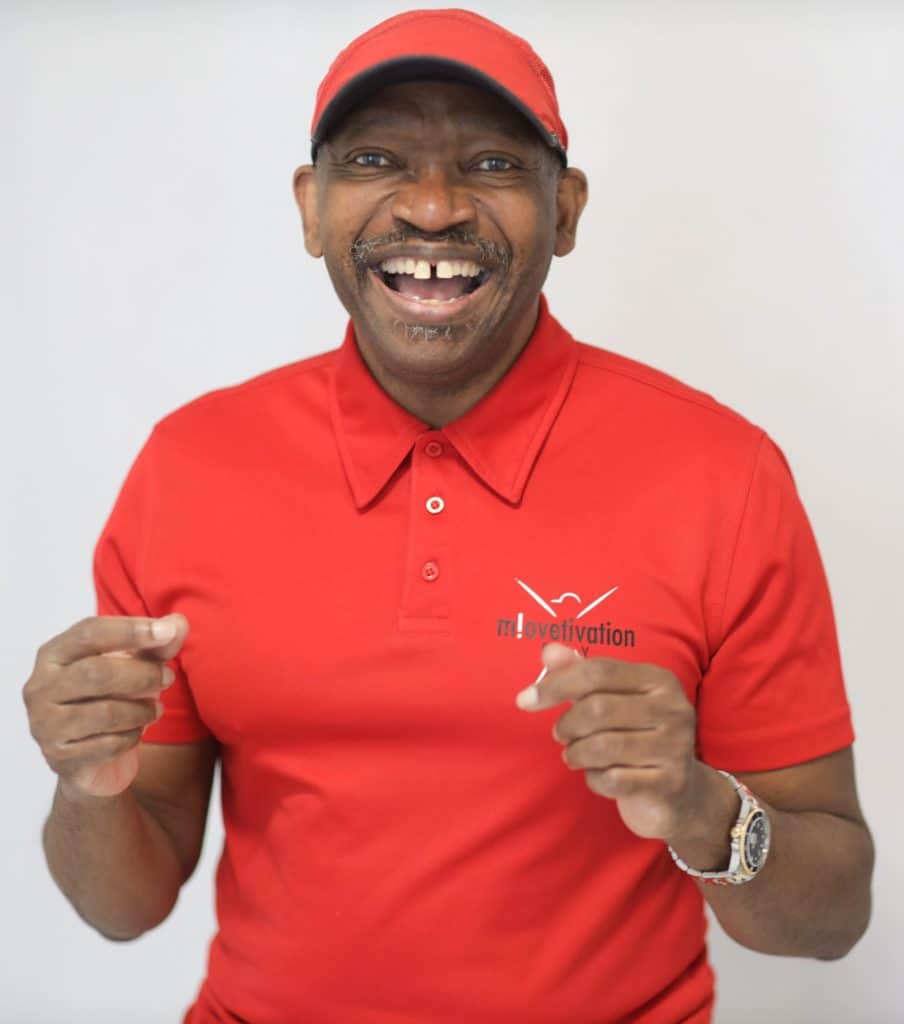 Mr. Move it! im roten Trikot zeigt lachend beide Daumen nach oben